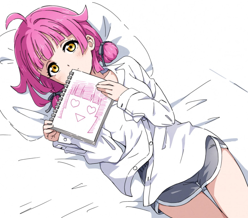 ahoge bed_sheet blunt_bangs blunt_ends breasts buttons commentary_request dolphin_shorts female grey_ribbon grey_shorts hair_ribbon heart heart-shaped_eyes highres holding holding_sketchbook light_blush light_smile long_sleeves looking_at_viewer love_live! love_live!_nijigasaki_high_school_idol_club lying medium_hair on_bed pillow pink_hair ribbon rina-chan_board shirt shorts sidelocks sketchbook small_breasts solo tennoji_rina thighs white_shirt yanekawara yellow_eyes