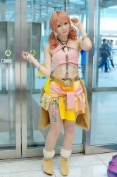  beads belt boots bracelet cosplay door female female final_fantasy final_fantasy_xiii jewelry midriff necklace oerba_dia_vanille oerba_dia_vanille_(cosplay) pink_shirt shirt skirt solo standing tile tiles twintails window 