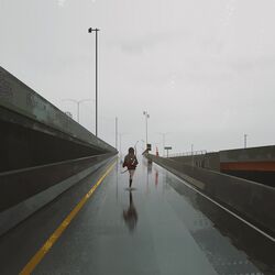  arrow_(projectile) bow_(weapon) female grey_sky highway hood jersey_barrier kneehighs lamppost landscape original outdoors overcast quiver rain reflection road road_sign sign skirt sky socks utility_pole weapon wet yun_ling 